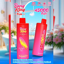A Promotional Image Featuring Two Vaping Devices Labeled 'Bang King Triple,' With Colorful Branding And Details Such As '45000 Puffs,' Set Against A Bright And Aesthetic Indoor Bathroom Background With Pink Flowers And A Large Window.