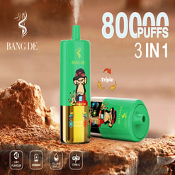 Promotional Image Of Bang De Vape Device Featuring A Green And Gold Design With A Monkey Illustration And Labels Highlighting Features Like 3-In-1 E-Liquid Flavors, 80,000 Puffs, 650Mah Battery, And Type-C Charging Port, Set Against A Rocky Backdrop.