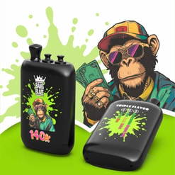 Black Vape Devices With A Cartoon Monkey Graphic, Green Splatter Background, And “140K” And “Triple Flavor” Text